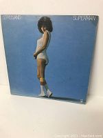 Back cover of Superman LP showing Barbra Streisand posing in white workout outfit on blue background.