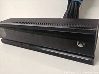 Front view of the Xbox One Kinect camera showing the sensor lenses and Xbox button on the front panel.
