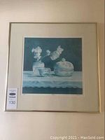 Framed limited edition print "Delicacies" by C. Moffat hung on a wall with a lot number tag attached to the frame corner.