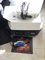 Photo showing Epson XP-400 printer, Nexxtech CD/radio on box, JVC camcorder on DVD case.