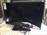 Front angled view showing the 28 inch RCA LED TV with attached cables.