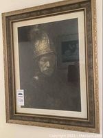 Framed print hanging on wall showing full view of artwork and frame.