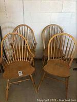 Set of four wooden chairs arranged in a group showing overall design and condition.