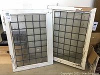 Two antique leaded glass windows with wooden frames, showing condition and size.
