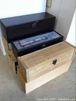 Five wooden wine boxes stacked, showing variety in size and finish