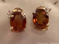 Front-view close-up of both earrings showing citrine color and diamond accent