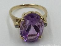 Front view of ring showing oval amethyst and two side diamonds