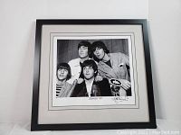 Framed black and white photograph of the Beatles from 1965 press conference signed by the photographer.