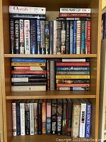 Books arranged standing on a shelf, showing a total of three shelves filled with books of various non-fiction subjects.