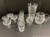 Photo showing entire lot of assorted crystal pieces including pitcher, vase, sorbet glasses, short glasses, and brandy snifter
