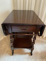 Front view of bar cart with drop leaves down and drawer closed