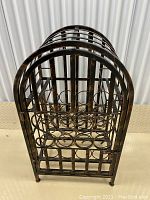 Front view of metal wine rack showing circular wine bottle holders and side structure