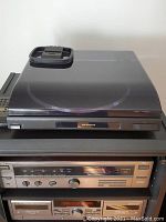 Optimus Lab-1000 turntable on top of stacked audio components with closed dust cover