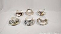 Front view showing all six bone china teacups with matching saucers arranged on white backdrop.