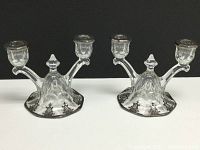 Pair of vintage glass double candleholders with silver overlay design on base and candle cup rims, viewed from front.