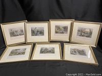 Seven framed prints arranged on fabric backdrop