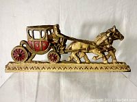 Front view showing detailed stage coach, horses, and driver with red painted accents on wheels and cabin.