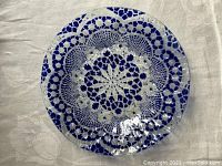 Full top view of the lace pattern decorative glass plate showing the cobalt blue and clear glass lace design.