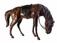 Side view of the large leather horse figurine showing detailed muscle carving and leather saddle and bridle with reins.