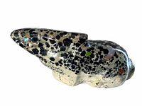 Side view of the speckled rabbit fetish showing the black and white speckled pattern and colored dots for eyes.