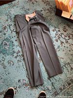 Four pairs of men's gabardine wool pants, dark grey, size 32, laid out on carpet