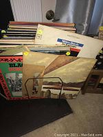 Front view of a metal rack holding a stack of album jackets; visible titles include Miles Davis in Europe and Black Byrd.