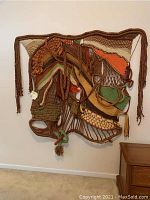 Front view of the large wall hanging featuring multiple braided ropes and woven fabric areas in warm earthy colors.