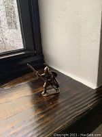 Front angle of the brass warrior figurine showing spear pointing forward and detailed armor.