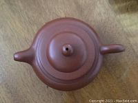 Top view of the Chinese clay kettle showing its shape, spout, handle, and lid with a ventilation hole.