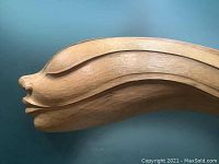 Close-up side view showing the elongated profile and smooth carving detail of the face.