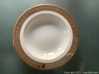 Top view showing the gold decorative rim on the white soup plate.