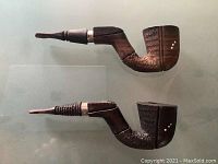 Photo showing two hand made wooden Moroccan smoking pipes side by side with detailed carved bowls and silver accent bands near the stems.