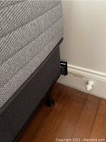 Close-up of mattress and bedframe side corner with flooring