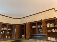Photo of kitchen cabinets with dinnerware, glassware, and canisters inside