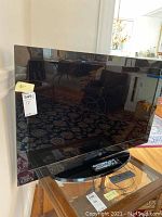 Front view of the 40-inch Westinghouse flat screen TV with stand and screen reflecting room.