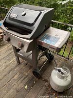 Front angle view showing hood, control panel, side shelf and propane tank connected