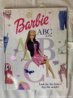 Front cover of the Barbie ABC Book featuring Barbie doll image, colorful alphabet letters, and related objects.