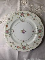 Top view of the round ceramic plate showing the full floral and gold edge design.