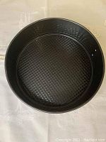 Top view of a medium size black springform pan showing textured base and sturdy walls.