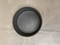 Top-down view of the Kaiser springform pan showing the embossed brand name on the base surface and the round shape.