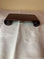 Front view of the cherry wood bonsai stand showcasing its smooth surface and curved legs.