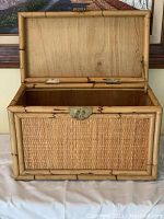 Open lid view showing the solid wood interior and metal hinge of the woven hay chest.