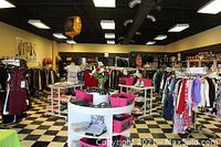 Interior photo of Auntie M's Closet showing a variety of new clothing items and accessories displayed on racks and shelves inside the store.