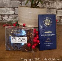 Chocolate bar labeled Cafe Blue Czar Jamaica Blue Mountain Coffee Dark Chocolate 57% cocoa next to Elpida Café branded chocolate block with visible nuts.