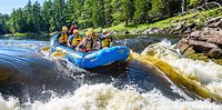 Group in inflatable raft navigating rapids on Ottawa River