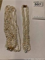 Two multi-strand freshwater pearl necklaces placed flat on a white background, showing their entirety and clasps.