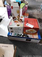 Photo showing stacked boxes containing Tiger electric grill, Grazia pasta maker, chopper machine, and micro simmer pot.