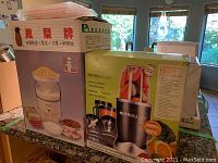 Photo of boxes for NutriBullet Magic Bullet nutrition extractor and a juicer showing packaging and some details.