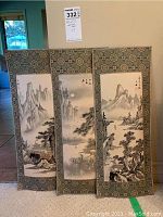 Three fabric-bordered landscape panels displayed together against wall