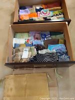 Drawer filled with multiple folded scarves in various colors and patterns